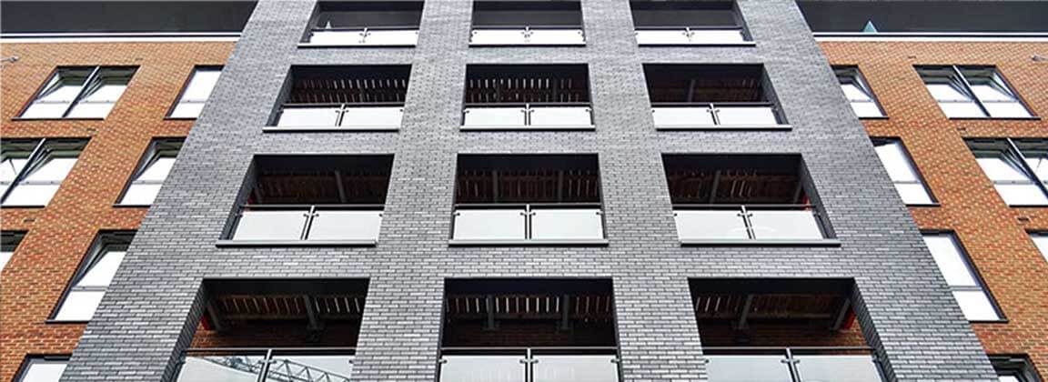 La pared exterior aplica ADD STONE WA revestimiento con color gris y rojo, que muestra su estabilización del edificio.